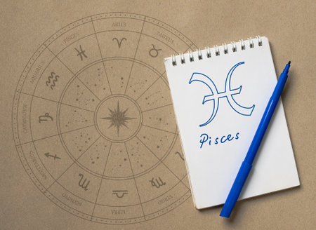 Notepad with pen and drawing of zodiac signの写真素材