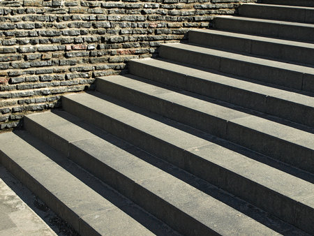 Steps of a stone staircase near a wall of small stones