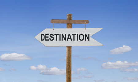 Against the sky, on a wooden stand, a white wooden arrow is suspended by ropes with the inscription.の写真素材