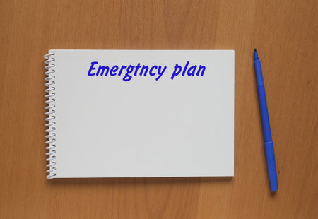 Open notebook with description: Emergency plan and marker on tableの写真素材