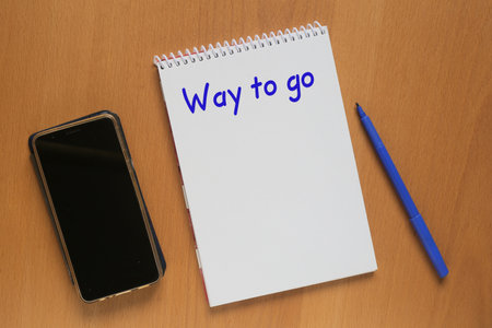 Open notebook with inscription: Way to go, mobile phone and marker on tableの写真素材