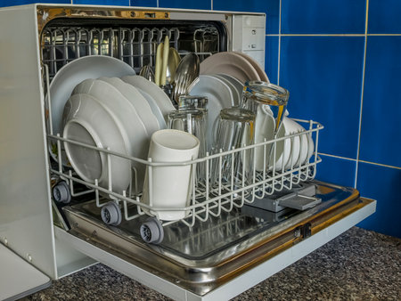 Open dishwasher with clean dishesの写真素材