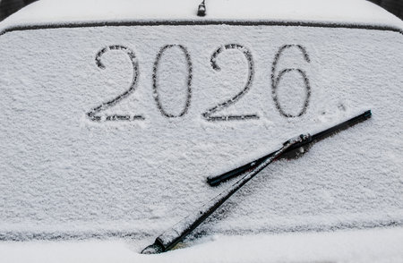 Drawing on the glass of a car covered in snowの写真素材