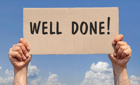 Hands holding a piece of cardboard with the inscription "Well done"の写真素材