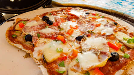 Self-made pizza on the pizzastoneの写真素材