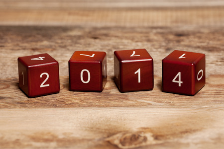Cubes with numbers isolated on old wooden background  Concept new year 2014 の写真素材