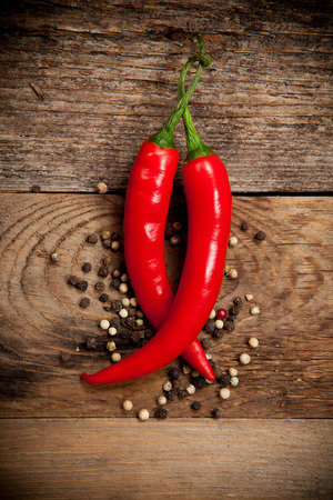 Red hot chili peppers on old wooden tableの写真素材