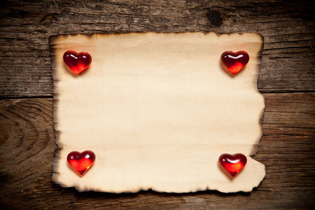 Horizontal old paper with glassware red heart on wooden backgroundの写真素材