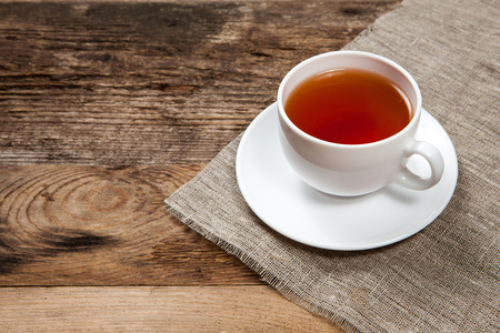 Cup of tea on old wooden tableの写真素材