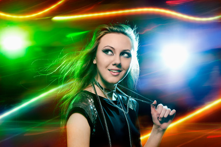 Pretty clubber dancing and looking at camera with smileの写真素材