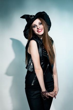 Beautiful witch stands and smiles. Halloween.の写真素材