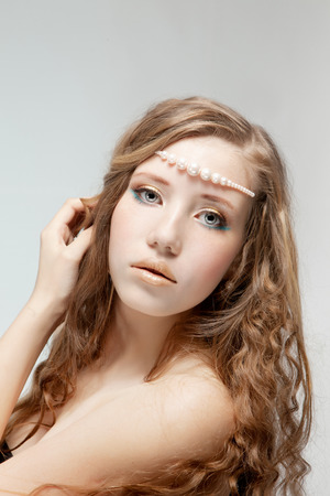 Beautiful woman with pearl-beads, on gray background.の写真素材