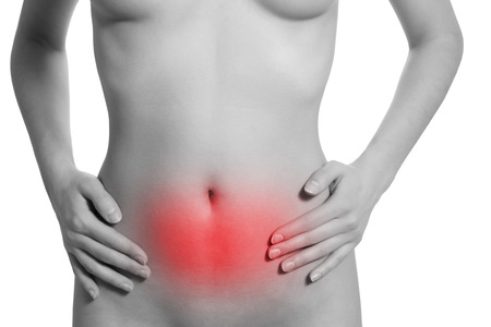 Woman suffering from stomachache, isolated on white background. Underbelly is highlighted by red colour.の写真素材