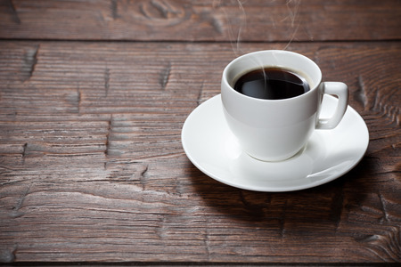Coffee cup and saucer on old wooden tableの写真素材