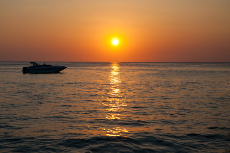 Speed boat in the sea at sunsetの写真素材