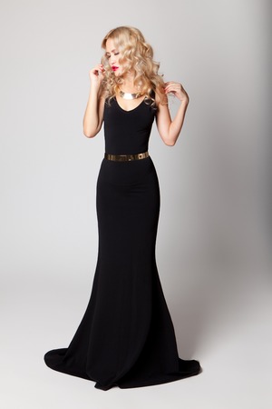 Beautiful woman model posing in elegant black dress in the studioの写真素材