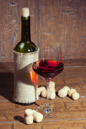 Wine bottles with glass on old wooden backgroundの写真素材