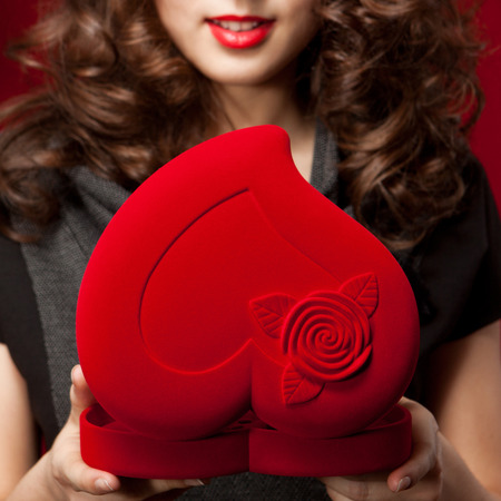 Young happy girl opening a gift on Valentine's Dayの写真素材