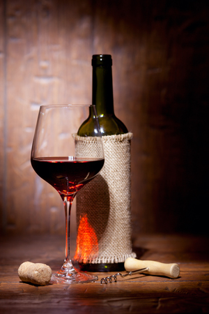 Wine bottles with glass on old wooden backgroundの写真素材