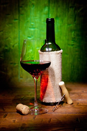 Wine bottles with glass on green old wooden backgroundの写真素材