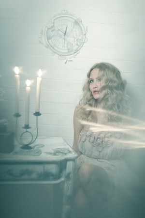 Pretty blonde woman in a white interior. Vintage cold colors with soft effect.の写真素材