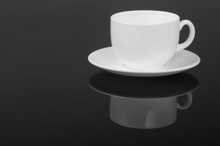White cup on glossy black background with reflection. With place for text.の写真素材