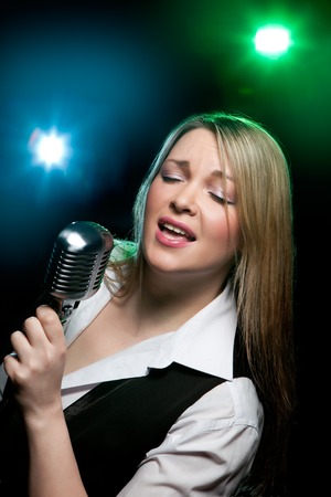 Singing woman with retro microphone.の写真素材
