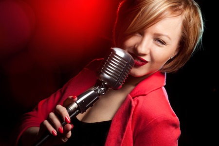 Singing woman with retro microphone.の写真素材