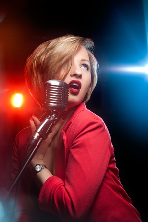 Singing woman with retro microphone.の写真素材