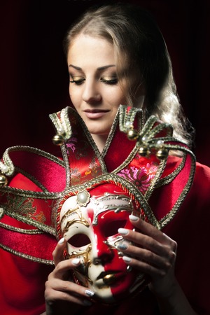 Close-up portrait of beautiful blonde woman hiding carnival venetian maskの写真素材