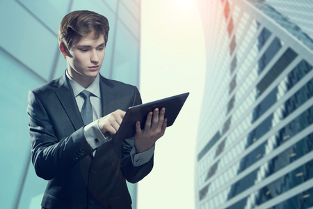 Portrait of young businessman with touch screen computer, in an urban settingの写真素材