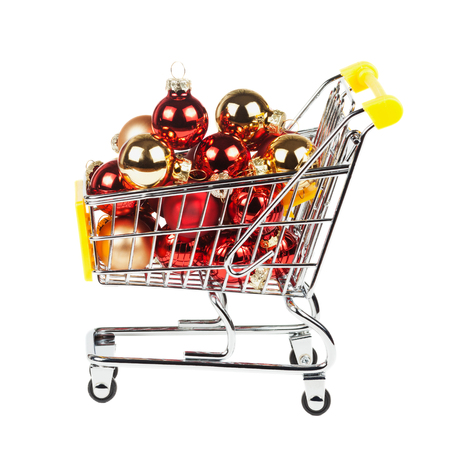Christmas balls in the shopping cart isolated on white background. Sale New Year concept.の写真素材