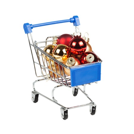 Christmas balls in the shopping cart isolated on white background. Sale New Year concept.の写真素材