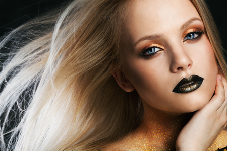 Fashion portrait of young caucasian model with golden sparkles on her neck.の写真素材