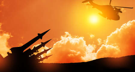 Missiles are aimed at a helicopter in the sky at sunset. Nuclear bomb, chemical weapons, missile defense, a system of salvo fire.の写真素材