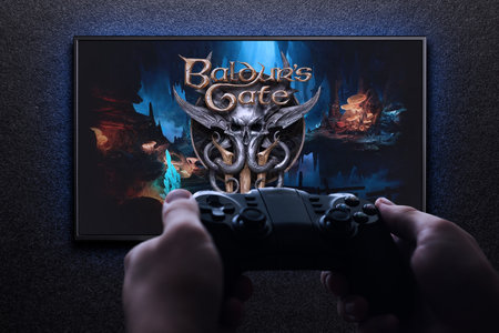 Baldurs Gate 3 game on TV with gamepad in hand on black textured wall with blue light. Astana,...