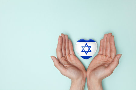 Heart with print of Israel flag in female hands. Flat lay. Copy space.の写真素材