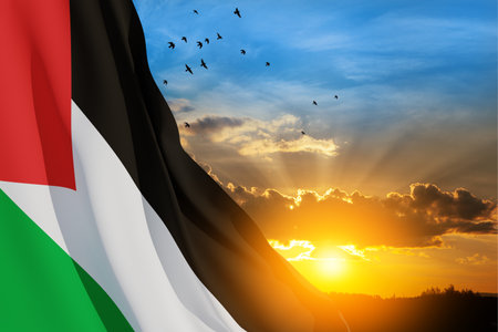 Palestine flag on background of sunset sky with flying birds. Patriotic concept. Banner with place for text.の写真素材