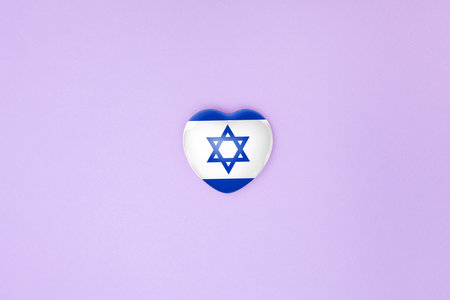 Top view or flat lay of heart with print of Israel flag on purple background with copy space. Flat lay. Copy space.の写真素材