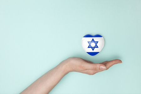 Heart with print of Israel flag in female hands. Flat lay. Copy space.の写真素材