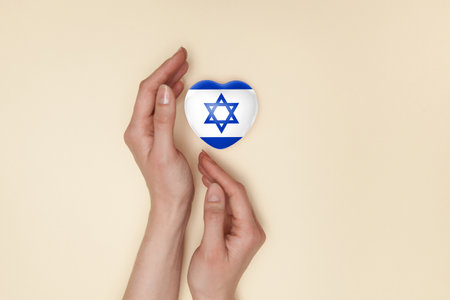 Heart with print of Israel flag in female hands. Flat lay. Copy space.の写真素材