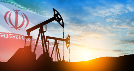 Oil drilling derricks at desert oilfield with Iran flag. The change in oil prices caused by the war. Oil prices are rising because of the global crisis. Crude oil production from the ground.の写真素材