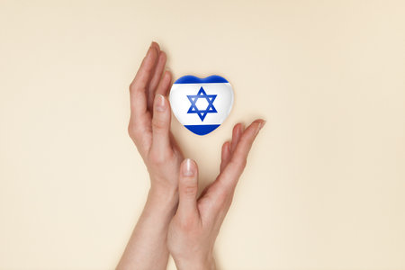 Heart with print of Israel flag in female hands. Flat lay. Copy space.の写真素材