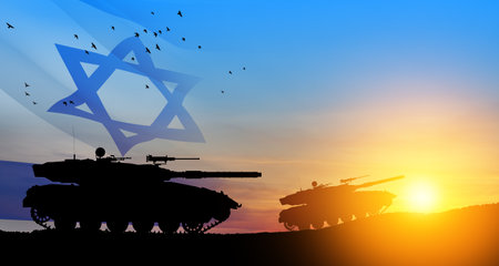 Silhouettes of army tanks at sunset sky background with Israel flag. Military machinery.の写真素材