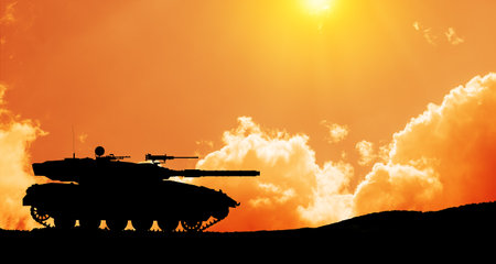 Silhouette of army tank at sunset sky background. Military machinery.の写真素材