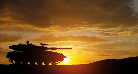 Silhouette of army tank at sunset sky background. Military machinery.の写真素材