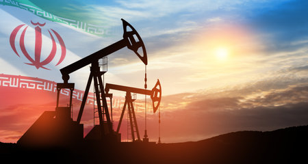 Oil drilling derricks at desert oilfield with Iran flag. The change in oil prices caused by the war. Oil prices are rising because of the global crisis. Crude oil production from the ground.の写真素材