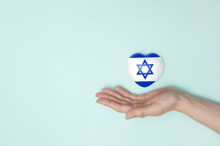 Heart with print of Israel flag in female hands. Flat lay. Copy space.の写真素材