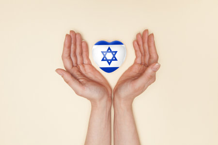Heart with print of Israel flag in female hands. Flat lay. Copy space.の写真素材