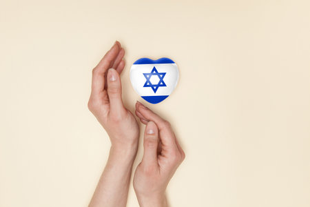Heart with print of Israel flag in female hands. Flat lay. Copy space.の写真素材